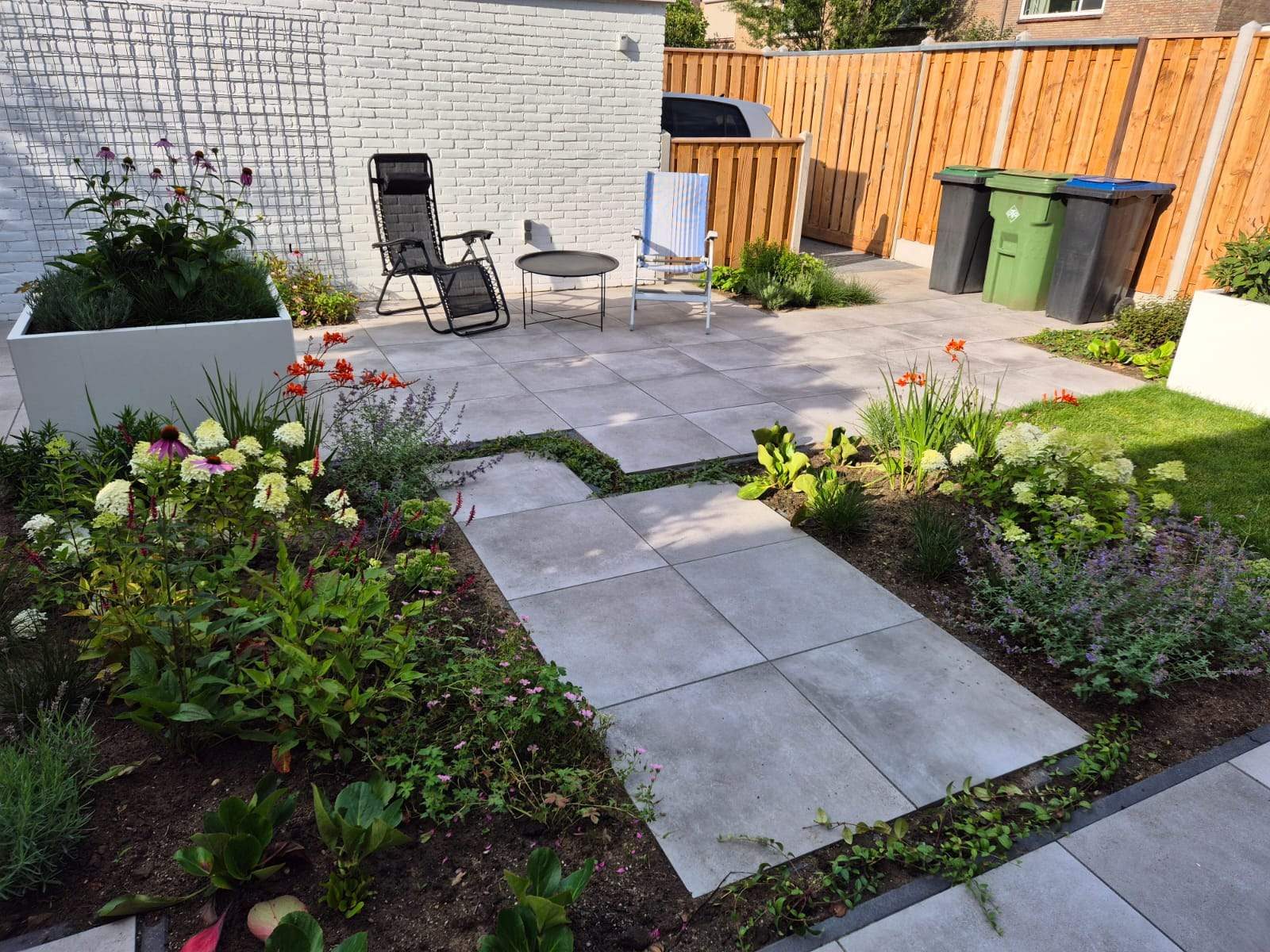 Achtertuin met terras, stapstenen pad en borders