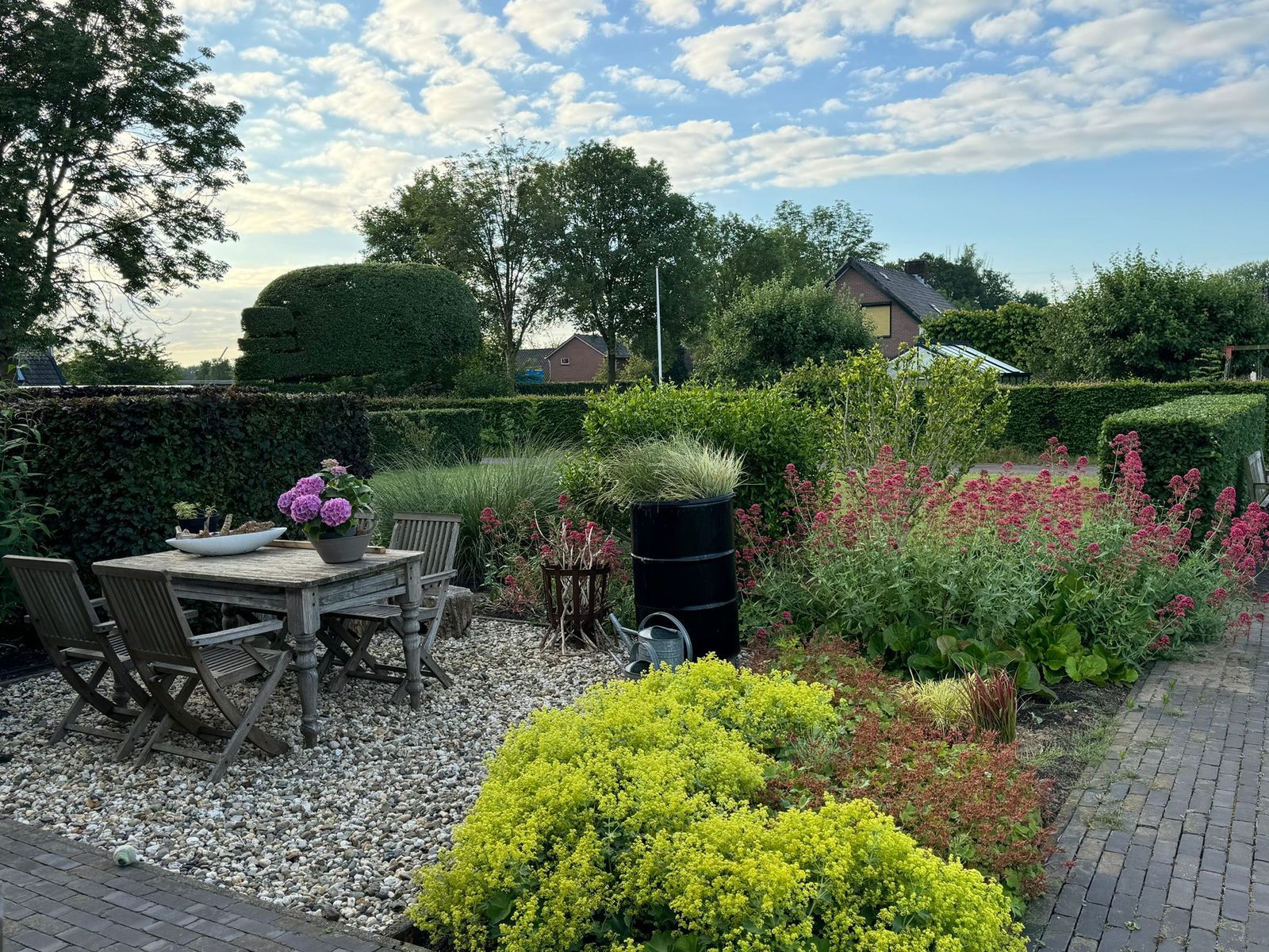 Verzorgde achtertuin met terras, borders en zithoek